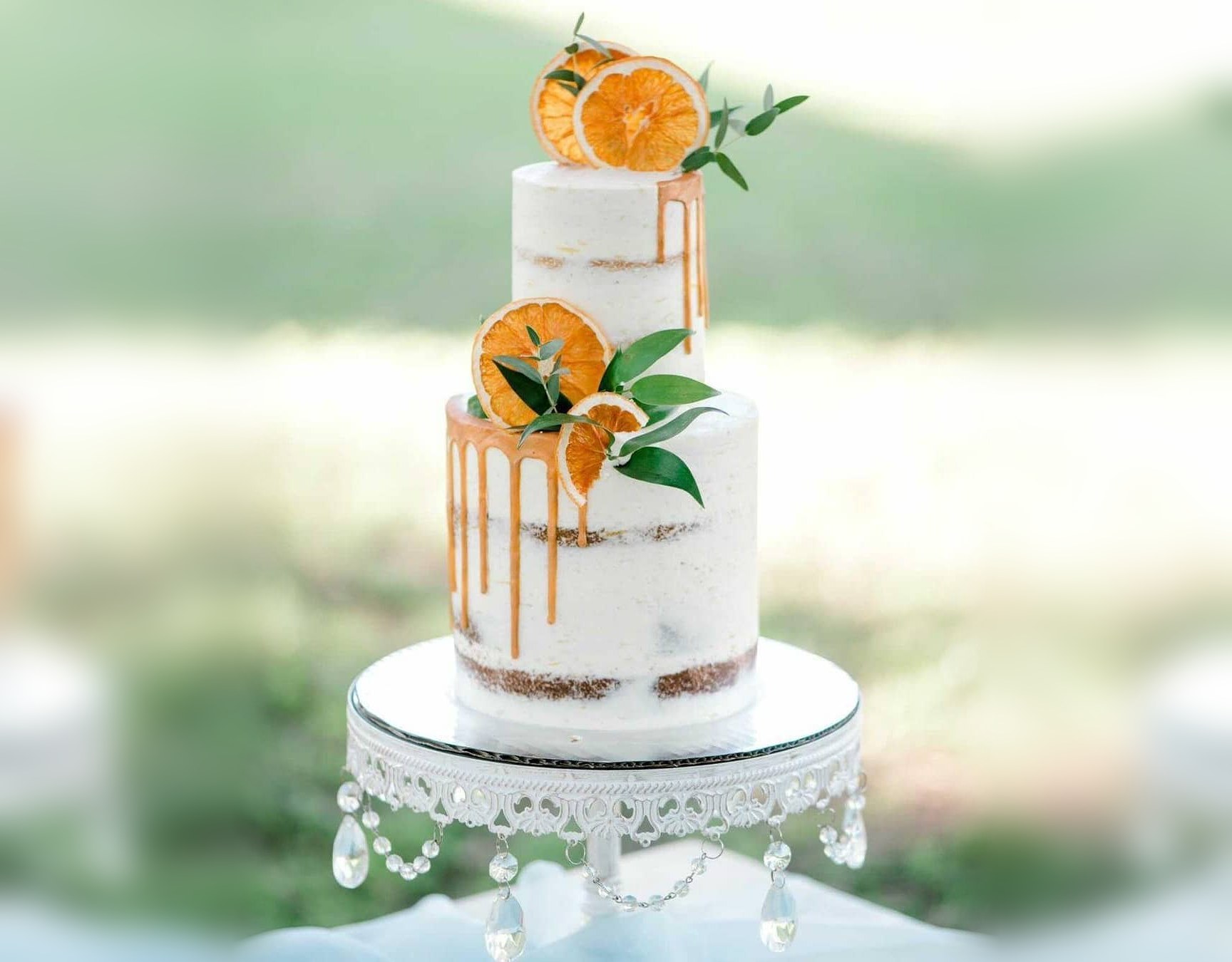 Two-tier semi-naked cake with a gold drip and dried orange slices