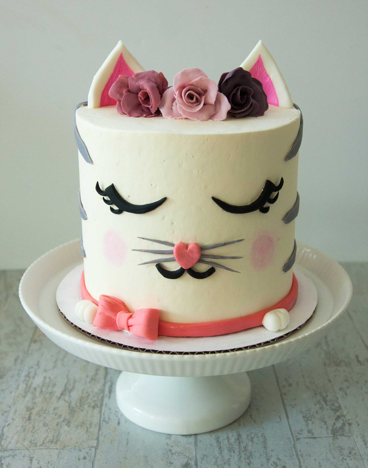 Cat face cake with buttercream ears, flowers and a pink collar
